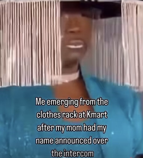 Photo of a partially obscured fave behind a hat with fringes around the edges with the caption “Me emerging from the clothes rack at Kmart after my mom had my name announced over the intercom”