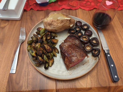 Strip steak, roasted brussel sprouts, baked potato, and sautéed mushrooms