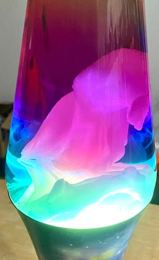 A multi-color lava lamp with a blob inside that vaguely resembles a small parrot, with beak and wing, facing to the right. Below it is an elongated blob that appears to have the shape and texture of a small tree branch.